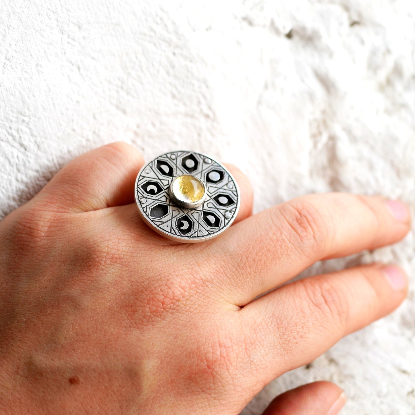 Bague ronde en argent, motifs géométriques et phases de la lune avec cristal de feuille d'or portée